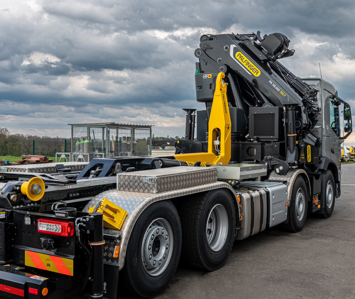 Camion grue Palfinger moderne sur terrain industriel.